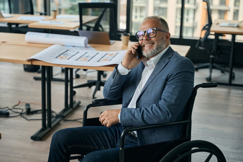 Employee in a wheelchair communicates on a mobile phone